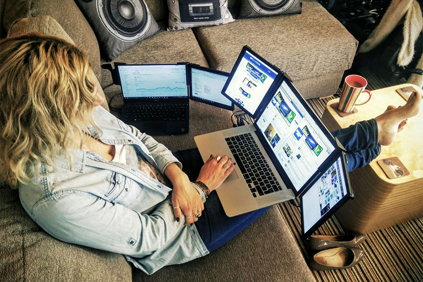 female on sofa using product with her laptop